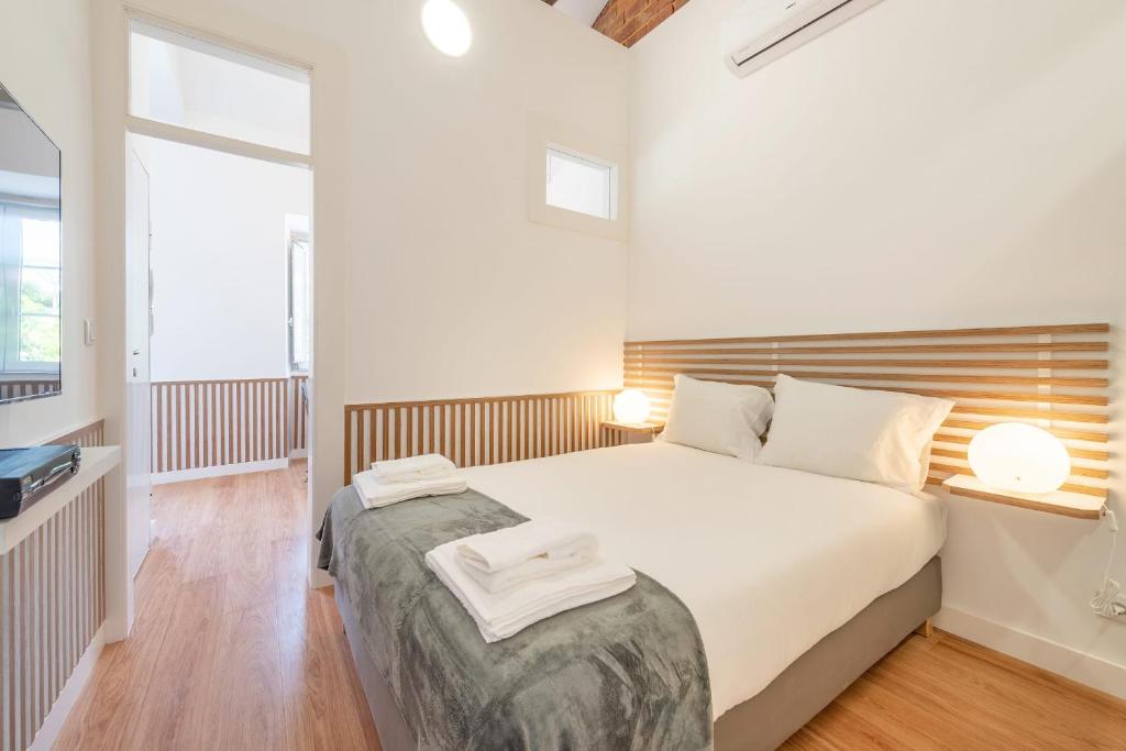 een slaapkamer met een bed met twee handdoeken erop bij GuestReady - Neoclassical-era Building in Lissabon