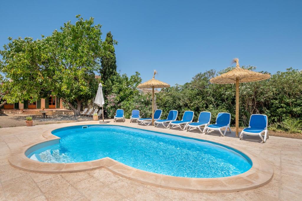 einen Pool mit Stühlen und Sonnenschirmen in der Unterkunft Casa Can Pauma in Ca's Concos des Cavaller
