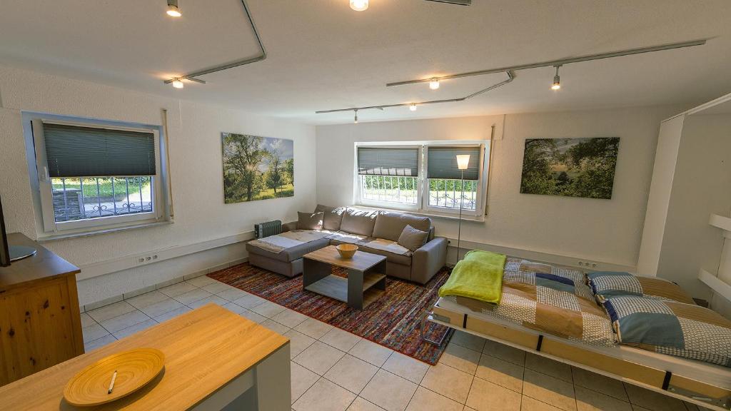 uma sala de estar com um sofá e uma mesa em Appartement Micha em Weissach Im Tal