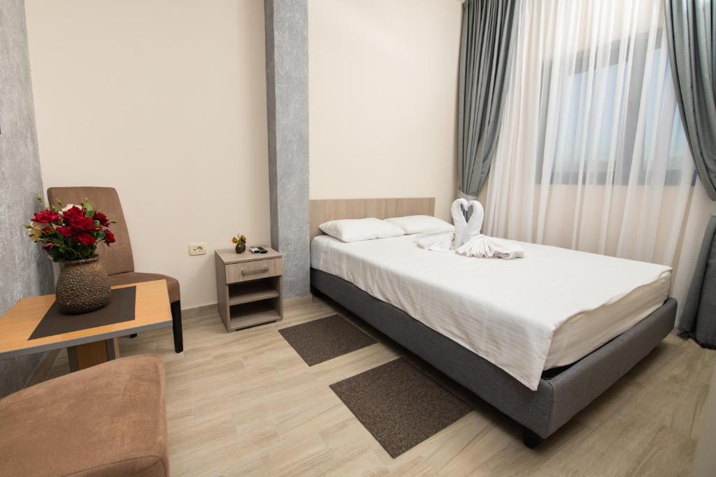 a small bedroom with a bed and a chair at IPN ROOMs 