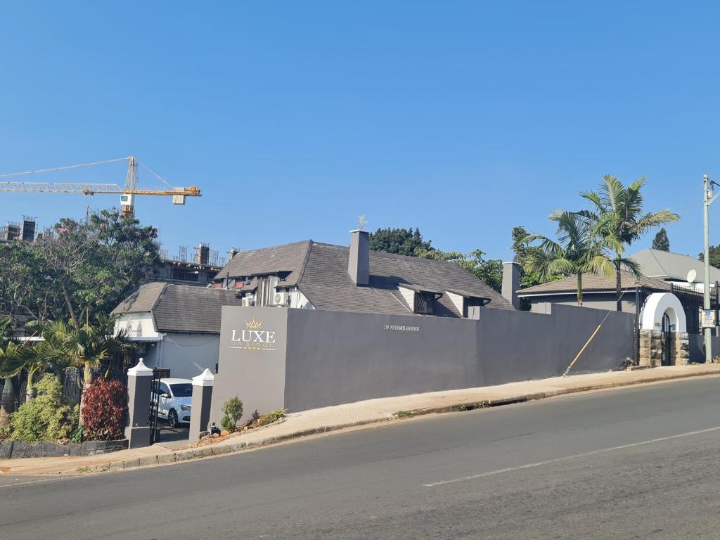 a building on the side of a road next to a street at Luxe on Ridge Boutique Hotel in Durban