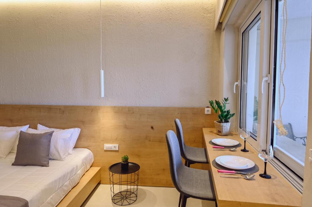 a room with a bed and a table with chairs at Eleftherias Suites - Near Beach Apartments in Marathi