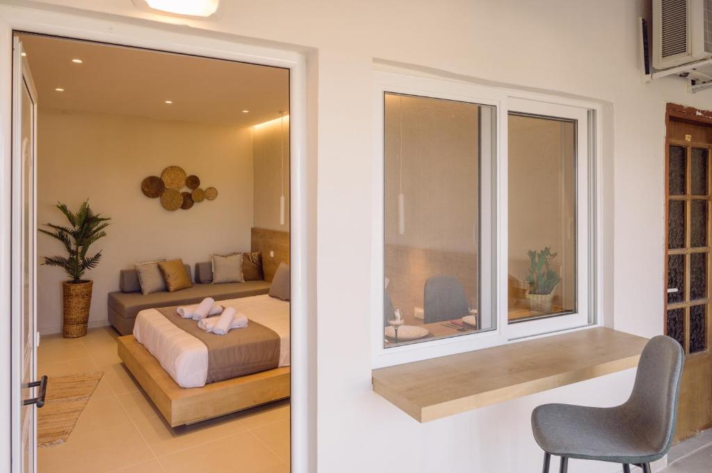 a bedroom with a bed and a large window at Eleftherias Suites - Near Beach Apartments in Marathi