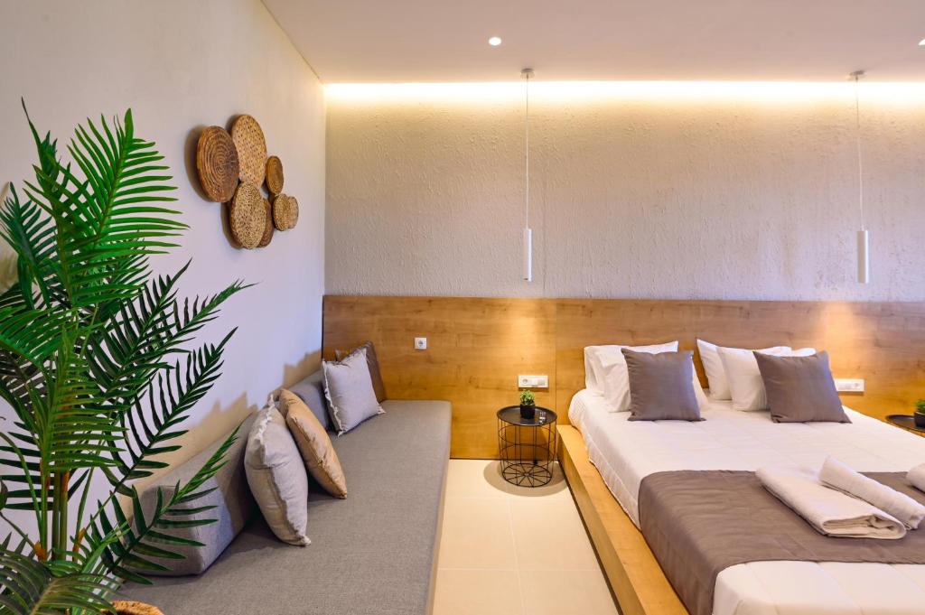 a room with two beds and a plant in it at Eleftherias Suites - Near Beach Apartments in Marathi
