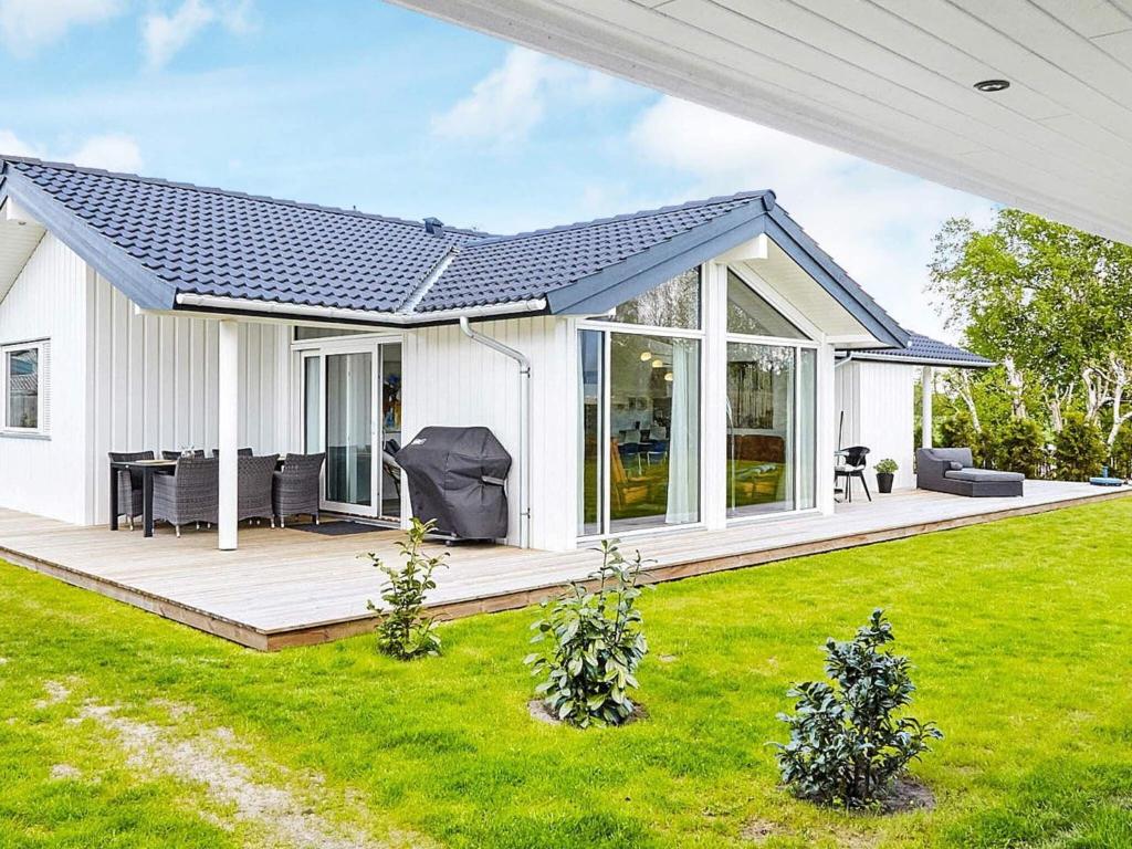a white house with a porch and a lawn at 7 person holiday home in Slagelse in Slagelse