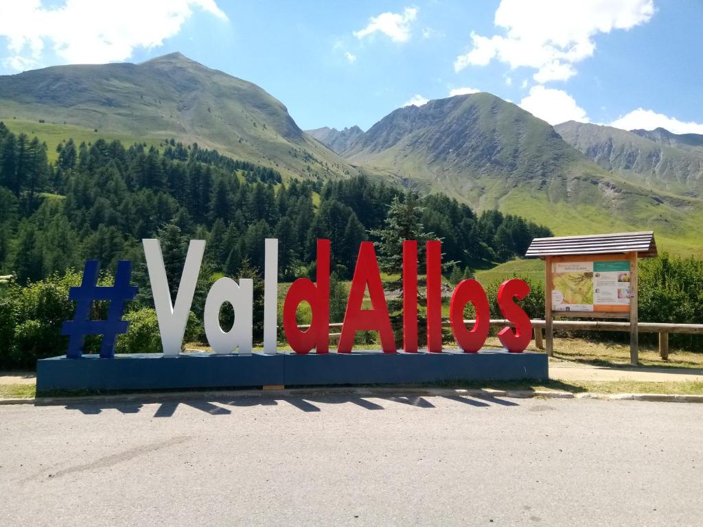 La Foux d'Allos Vacances nature Espace Lumière في لا فوكس: علامة كبيرة مع الجبال في الخلفية