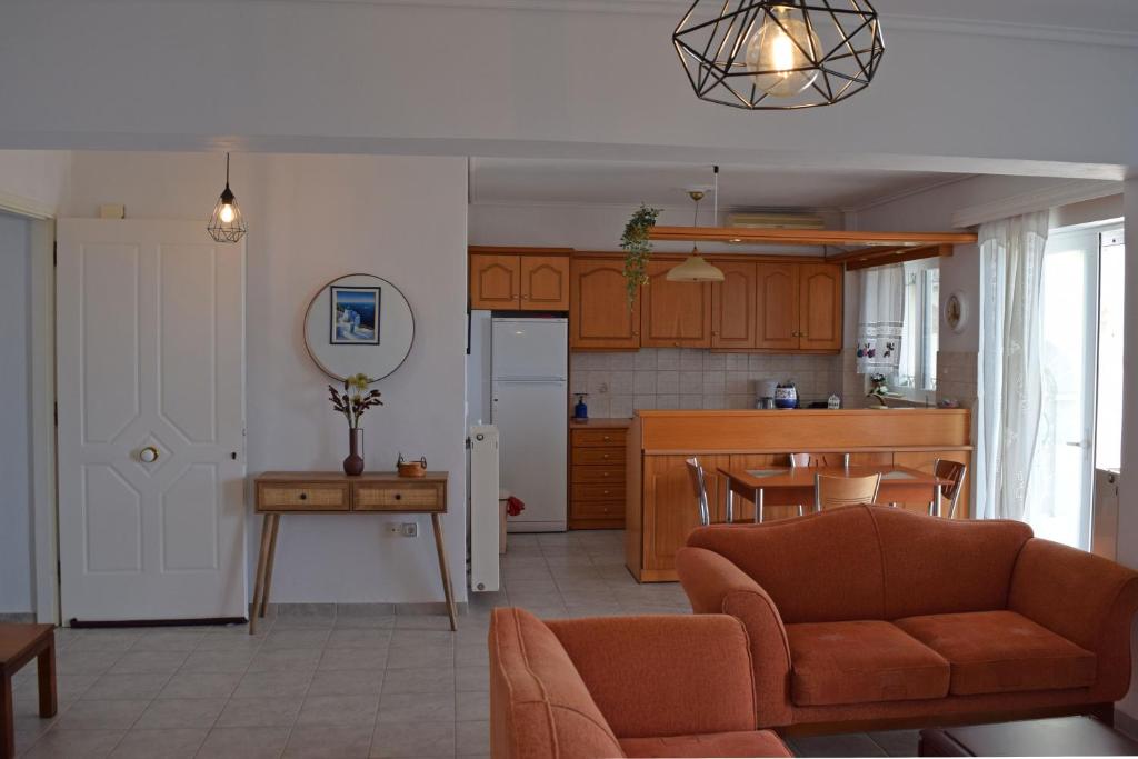 a living room with a couch and a kitchen at Corinthian Gulf View in Egira