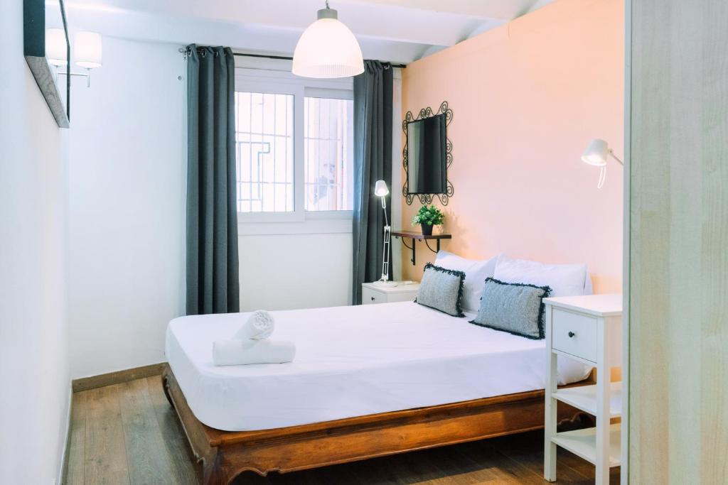 a bedroom with a white bed and a window at Cozy place next to Park Güell in Barcelona