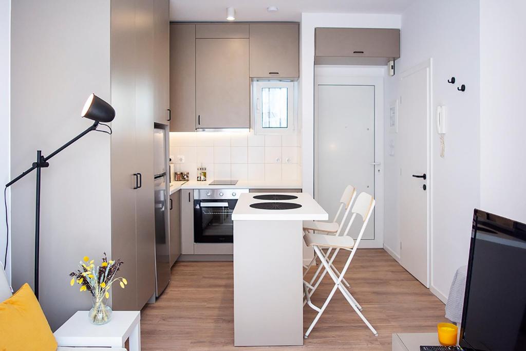 a small white kitchen with a counter and a stove at Stylish Modern Studio, Chalkida centre, seaside in Chalkida