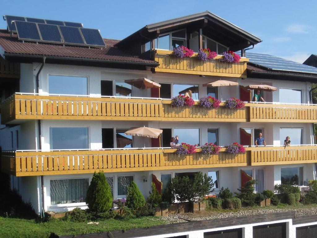un bâtiment avec des balcons fleuris et des panneaux solaires dans l'établissement Haus Panorama, à Oy-Mittelberg