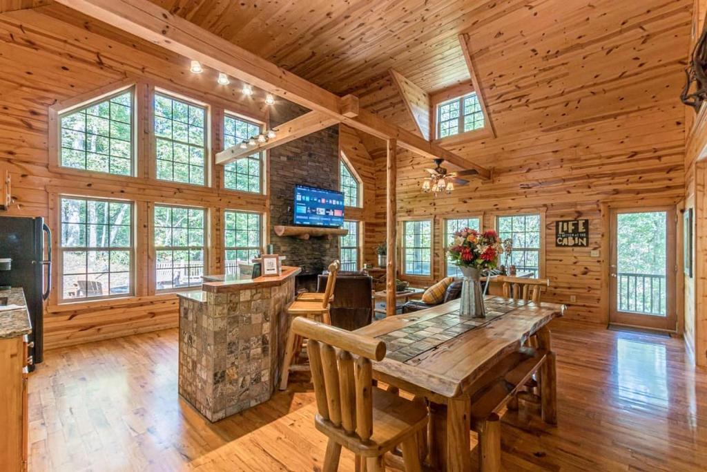 a dining room with a table in a log cabin at Cozy Creekside Log Cabin w Firepit, Hot Tub, WIFI in Cleveland