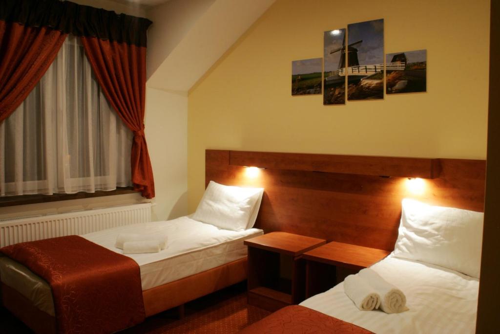 a hotel room with two beds and a window at Hotel Kuźnia Oberża Polska in Łysomice