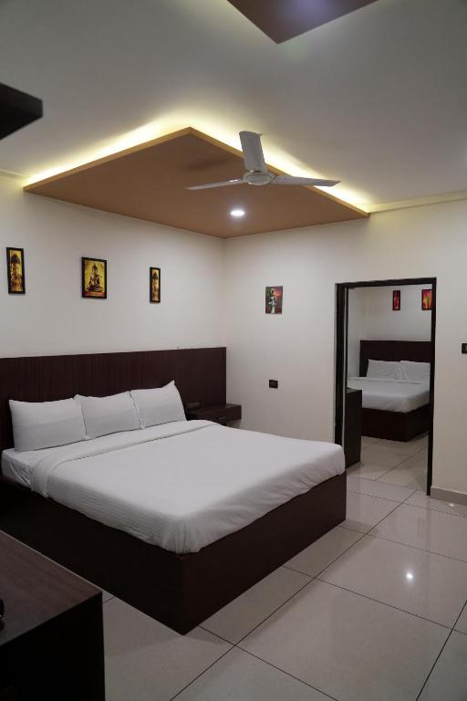 a bedroom with a large bed with a ceiling at Srirengavilasam Elite - Srirangam in Tiruchchirāppalli