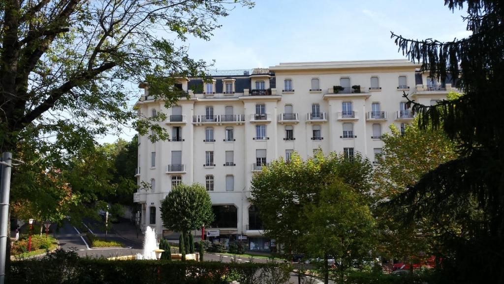 a white building with a fountain in front of it at Appartement idéalement situé pour curiste in Châtel-Guyon