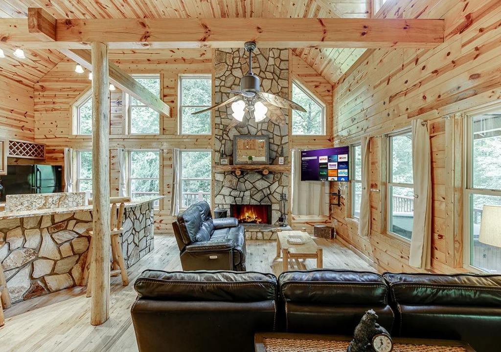 a living room with a fireplace in a log cabin at Private Luxury Cabin w Pool Table and Firepit in Cornelia