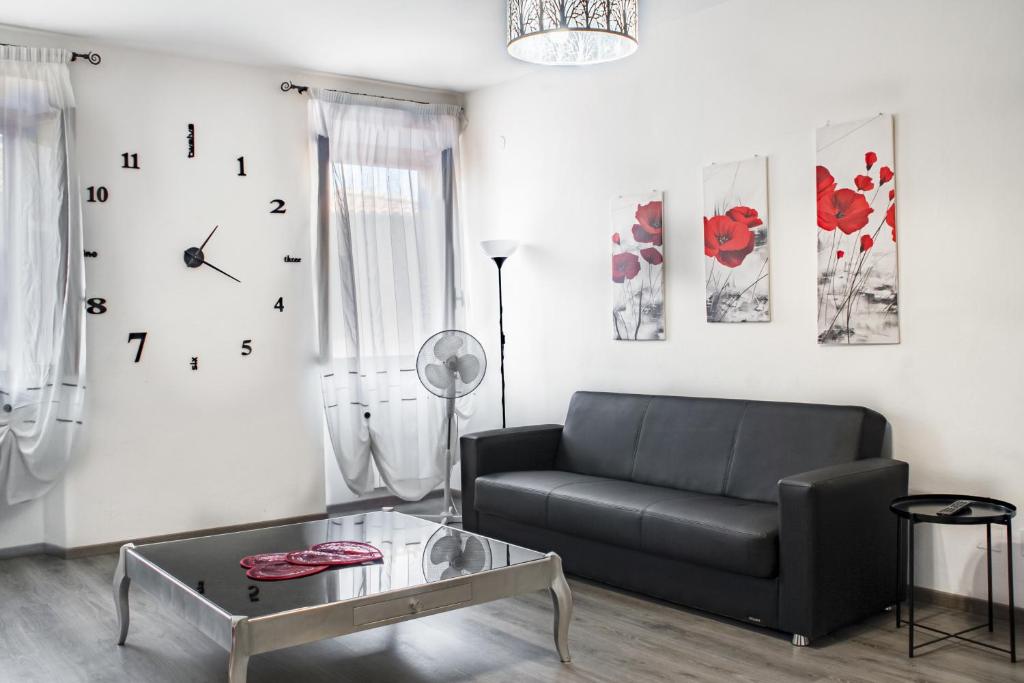 - un salon avec un canapé et un réveil sur le mur dans l'établissement Casa La Fortezza, à Livourne