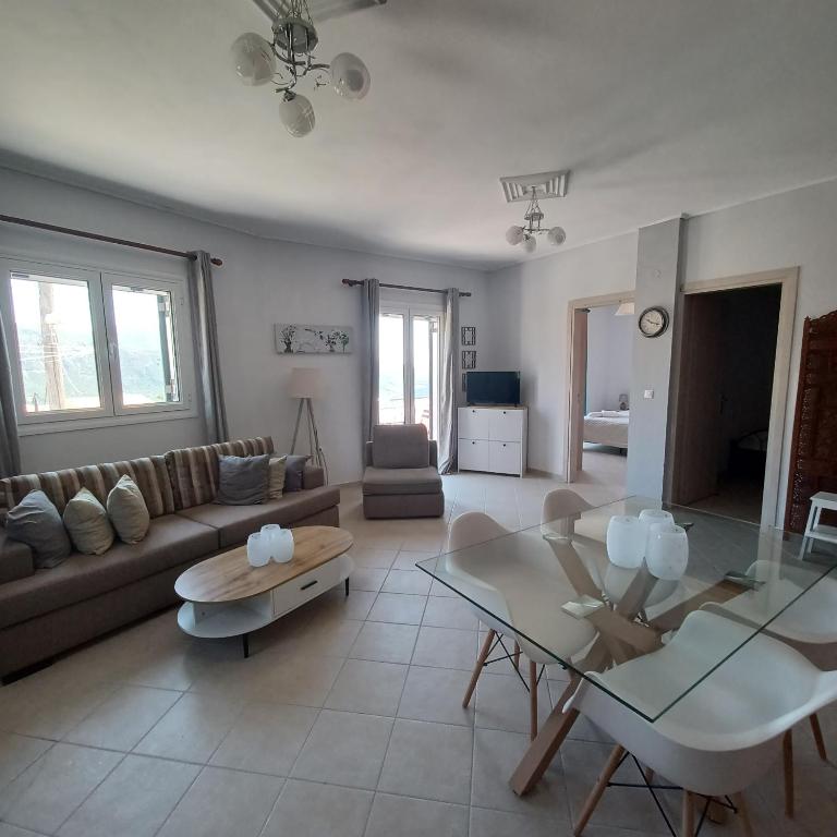 a living room with a couch and a glass table at Jerrys Home Agios Petros in Áyios Pétros