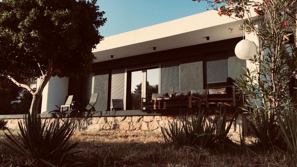 マリ・ロシニにあるHoliday house Manokaの窓と椅子が前にある家