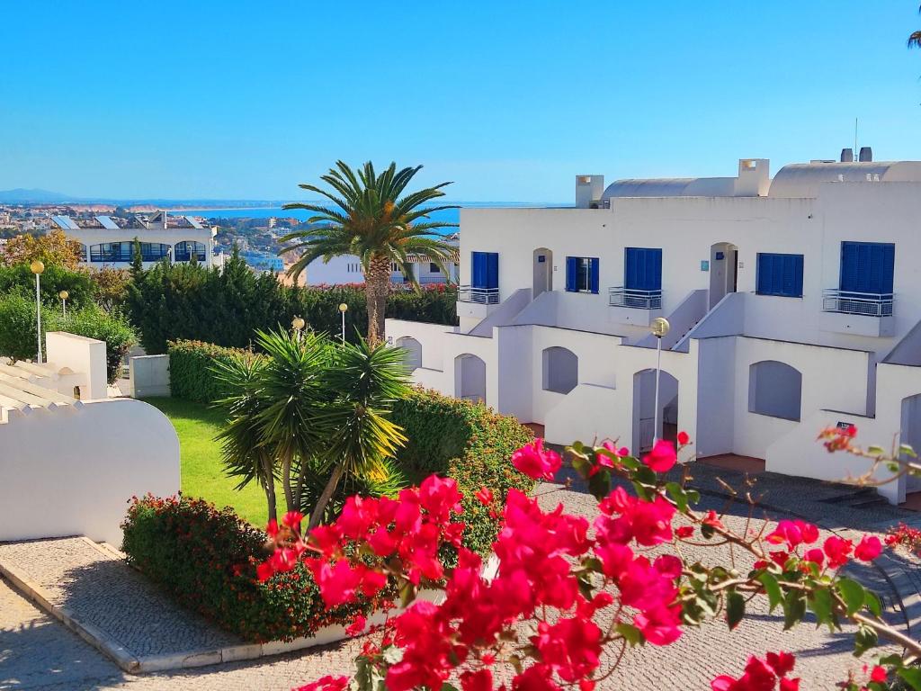 a view of a white building with pink flowers at Luxury Townhouse in Top Complex with Town and Ocean View by Be Cherish in Albufeira