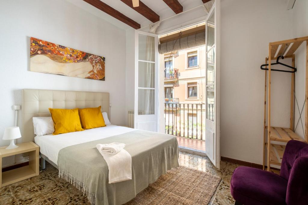 a bedroom with a bed with yellow pillows and a window at CENTRIC APARTMENT GAUDI in Barcelona