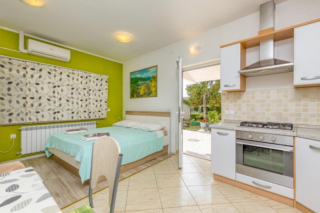 sypialnia z łóżkiem i kuchnią w obiekcie Studio Gordana with Terrace w mieście Funtana
