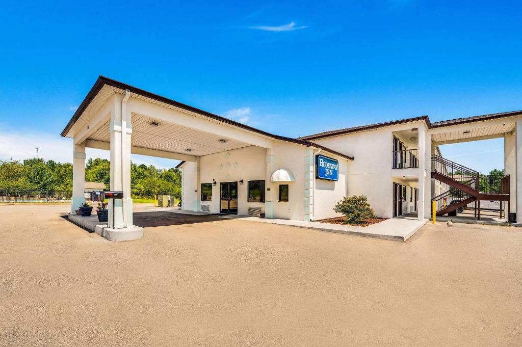 un gran edificio blanco con garaje abierto en Rodeway Inn Sandersville, en Sandersville