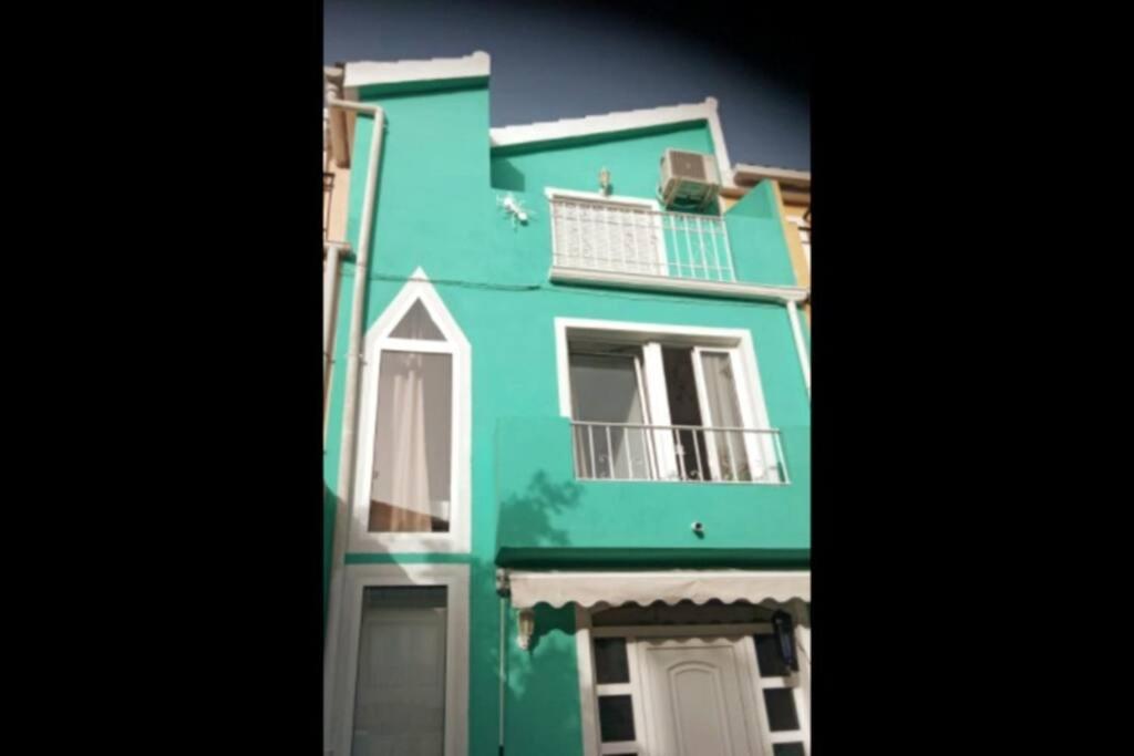 un edificio verde con 2 balcones en Agradable adosado cerca de la playa, en Benicàssim