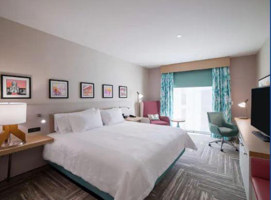 um quarto de hotel com uma cama grande e uma secretária em Hilton Garden Inn Visalia, Ca em Visalia