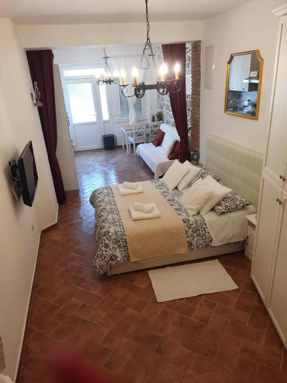a bedroom with a large bed and a living room at Old Town Rab Studio apartment in Rab