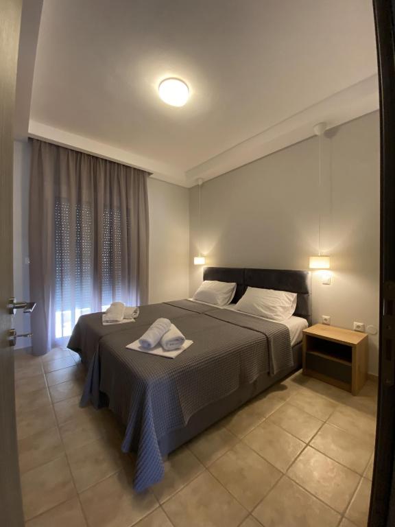 a bedroom with a bed with two towels on it at Hellen's Apartments in Ofrínion