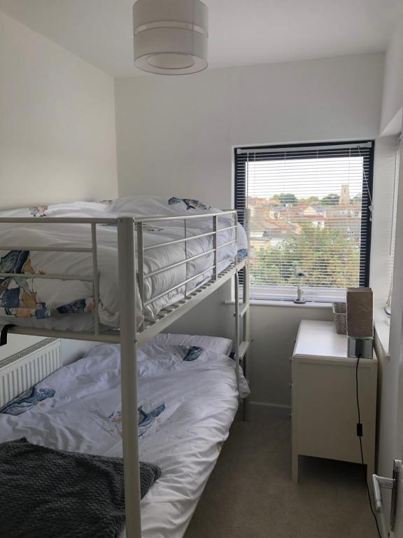 1 dormitorio con 2 literas y ventana en Penthouse Apartment with seaviews, en Walton-on-the-Naze