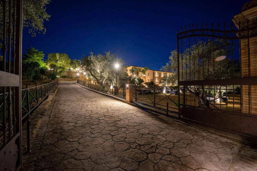 una calle vacía por la noche con una valla en Tenuta Ciminata Greco, en Rossano