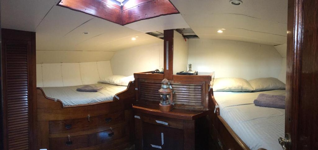 a room with two beds in a boat at Eco-responsible stay on the historical sailing boat of the Gaiarta Project - come and stay with our crew and get the whole boat experience in Saint-Cyprien