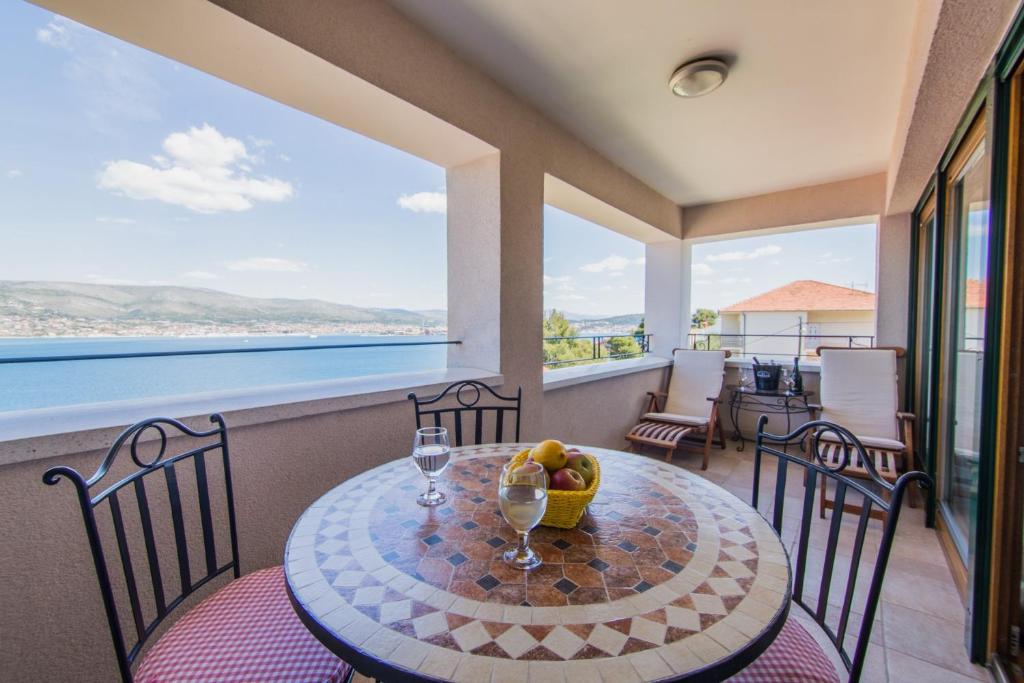 a dining room with a table and chairs with a view of the ocean at Villa Novak in Okrug Donji