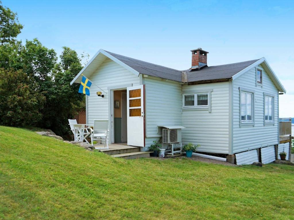 ein kleines weißes Haus mit einer Veranda und einer Liegewiese in der Unterkunft 5 person holiday home in Uddevalla in Uddevalla