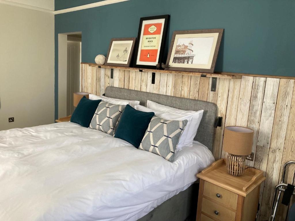 a bedroom with a white bed with a wooden headboard at Downs Hotel in Stanmer