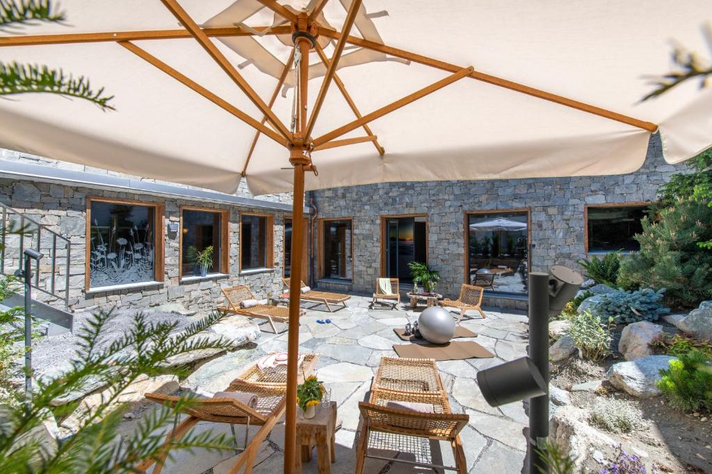 a patio with chairs and an umbrella at Hôtel de Verbier SUP in Verbier