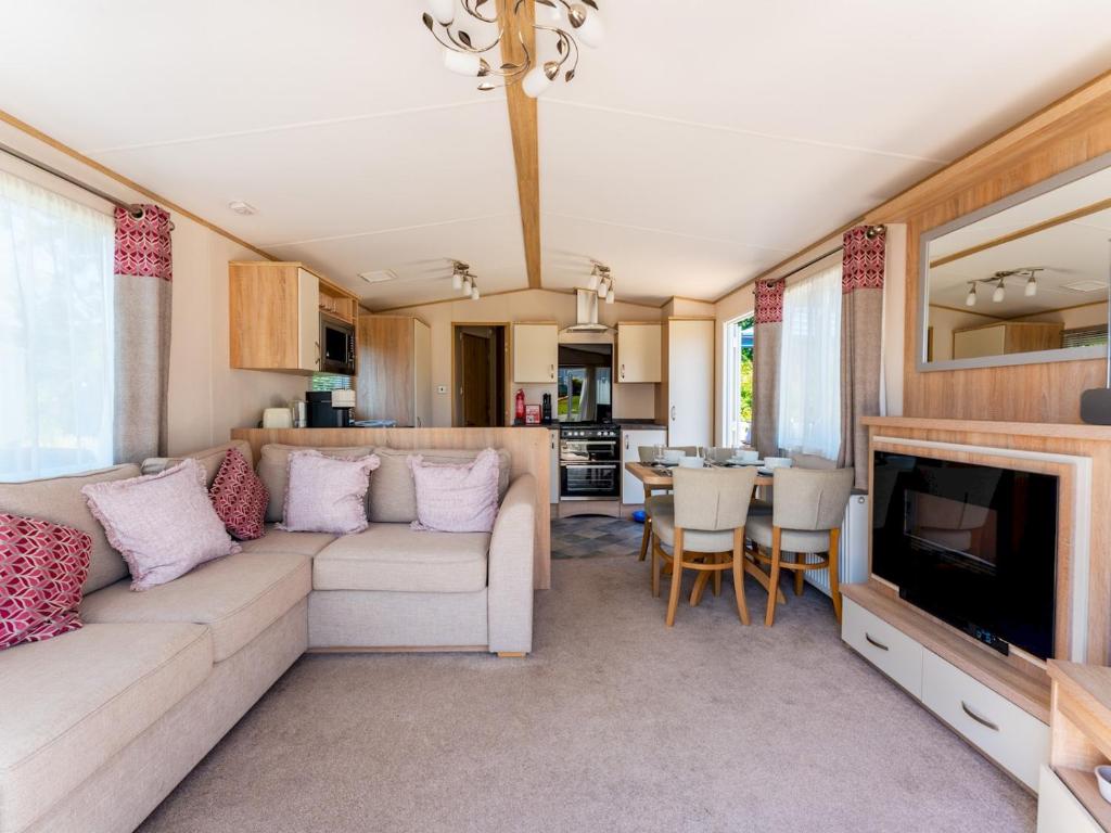 ein Wohnzimmer mit einem Sofa und einem TV in der Unterkunft Pass the Keys Delightful 2 bedroom caravan with parking in Wimborne Minster