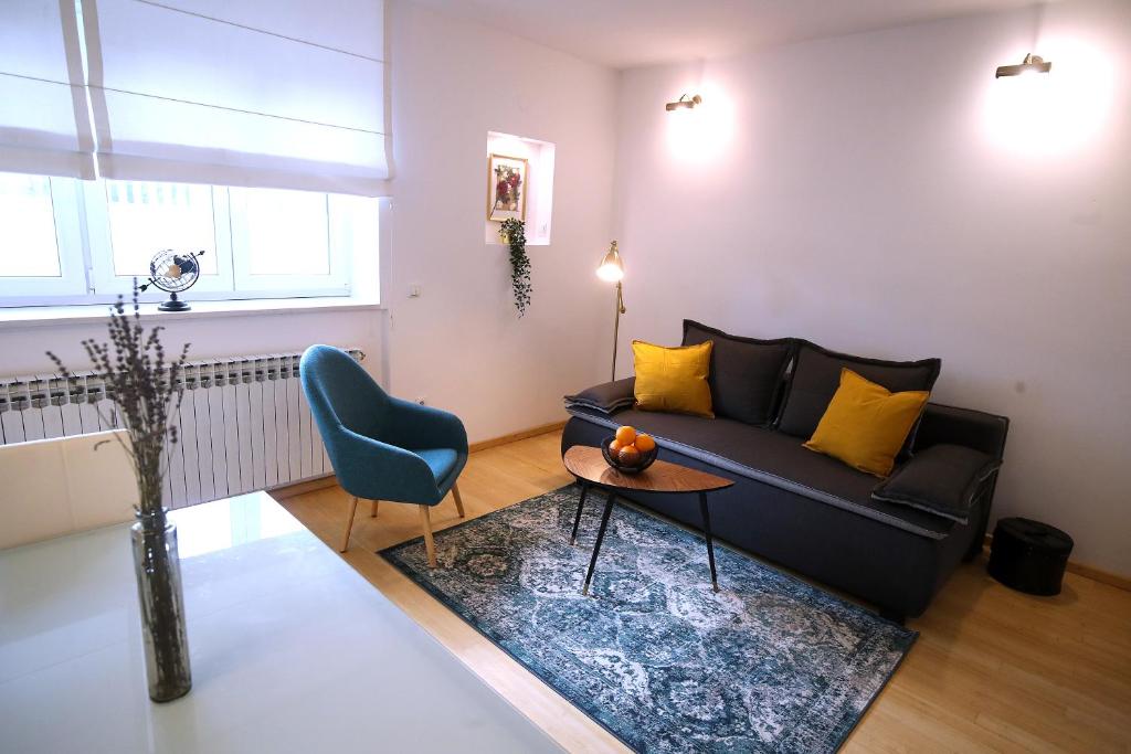 a living room with a black couch and a table at La Vie Est Belle in Zagreb