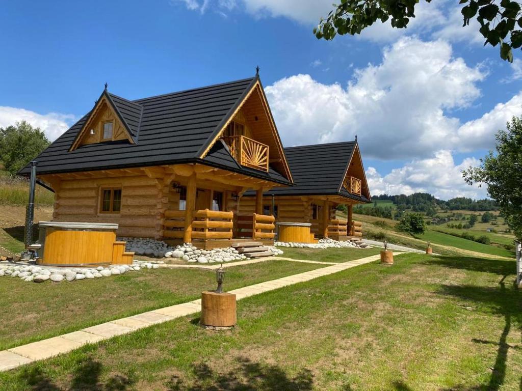 Cabaña de madera grande con techo negro en Domki Gorce Klikuszowa- sauna, jacuzzi, en Klikuszowa