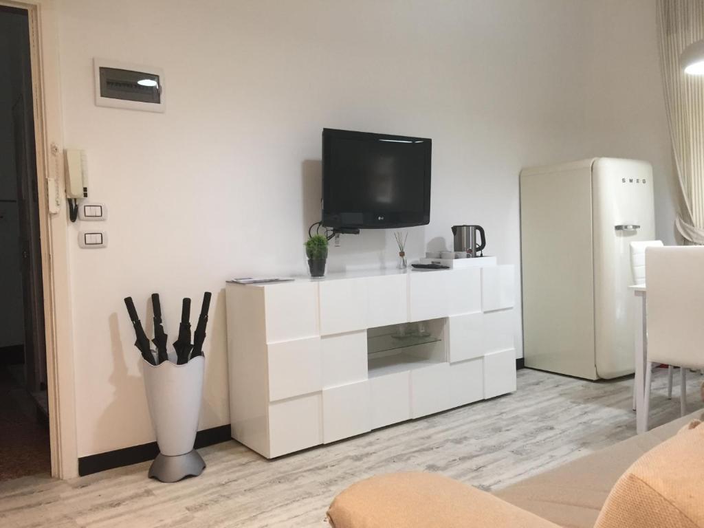 een woonkamer met een witte dressoir en een tv. bij ca Debora Apartment in Rapallo