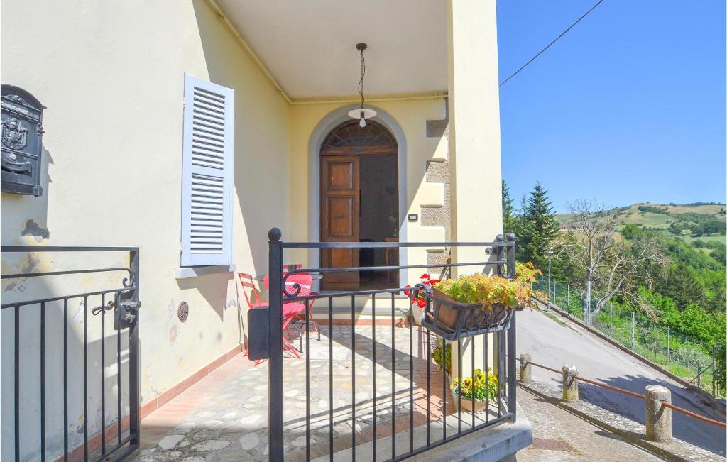 Casa con balcón con puerta y flores en Lovely Apartment In Monte Cerignone With Kitchen, en Monte Cerignone