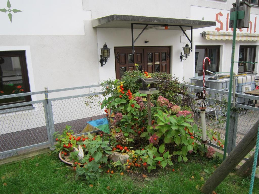 un jardín con flores frente a un edificio en Waldpension Stachl en Bromberg