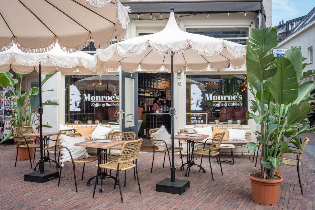 a restaurant with tables and chairs under an umbrella at Monroe’s stay in Deventer