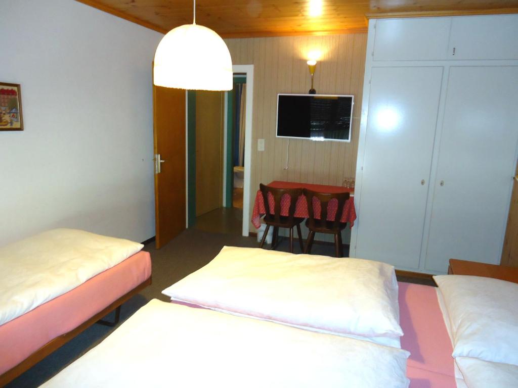 a room with two beds and a dining room at Hotel de l'Union in Orsières