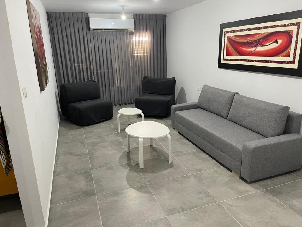 sala de estar con sofá y 2 sillas en Menachem's Apartment, en Beit She'an