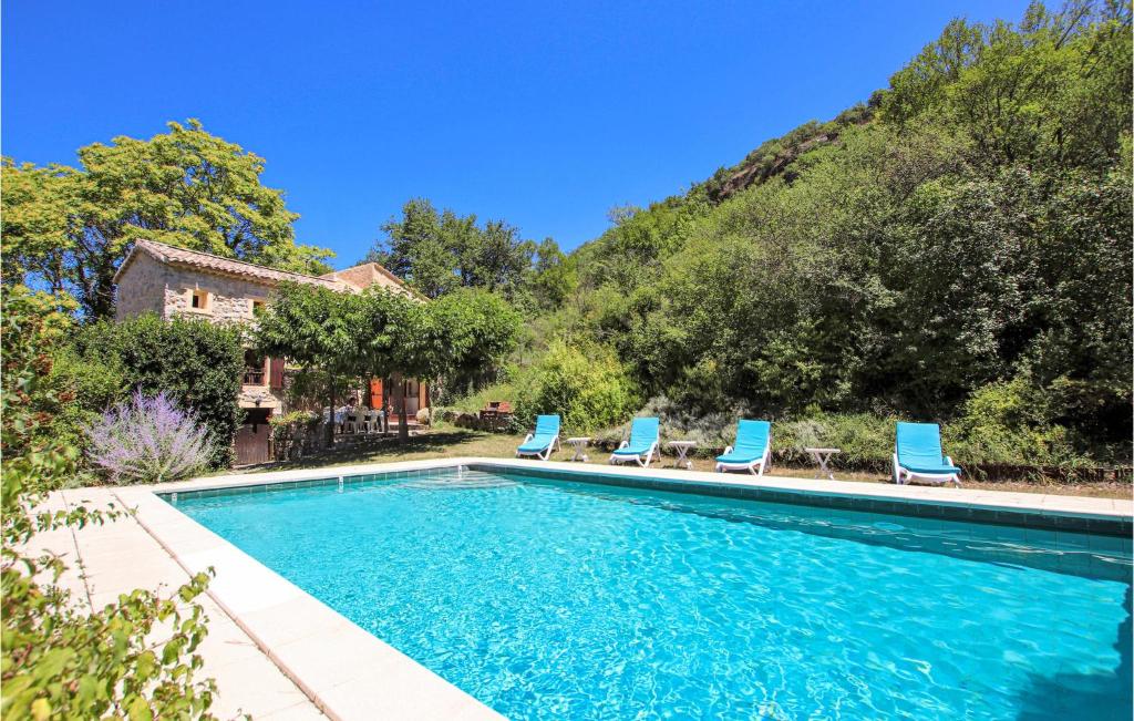 una piscina con sillas azules y una casa en Awesome Home In Curnier With Outdoor Swimming Pool, en Curnier