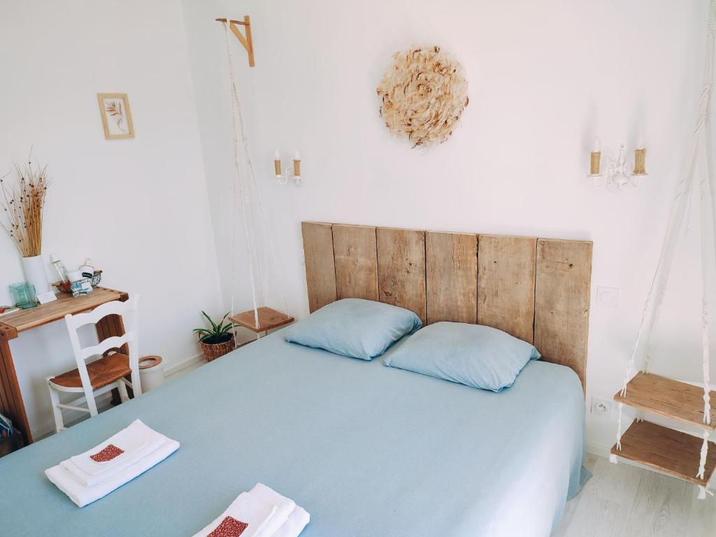1 dormitorio con cama azul y cabecero de madera en Les soleils de la Loire, en Ingrandes