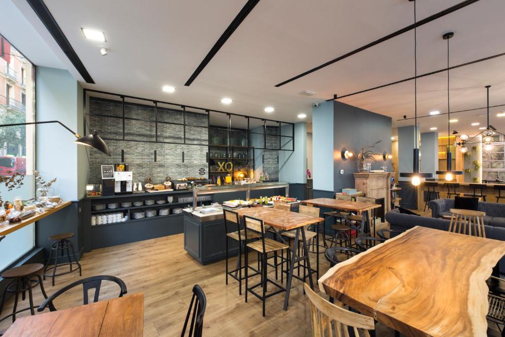 Un restaurante con mesas y sillas y un bar. en Petit Palace Triball, en Madrid