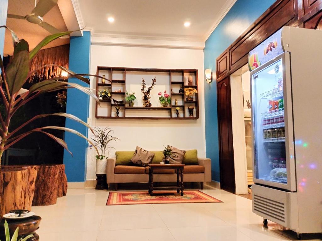 a living room with a couch and a refrigerator at Bed & Bedzzz in Siem Reap